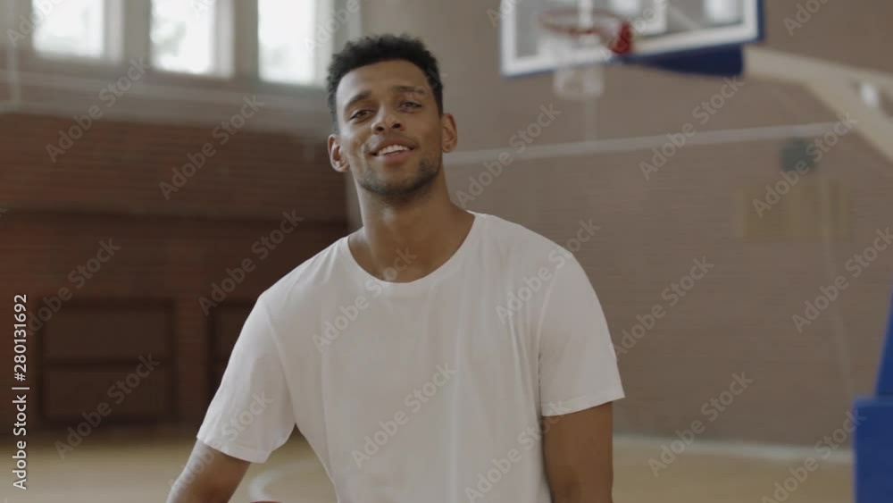 CU Portrait of young confident African American black college basketball player in casual sport clothes posing with a ball, looking into camera. Shot on ARRI Alexa Mini, 4K RAW graded footage CU Portrait of young confident African American black college basketball player in casual sport clothes posing with a ball, looking into camera. Shot on ARRI Alexa Mini, 4K RAW graded footage