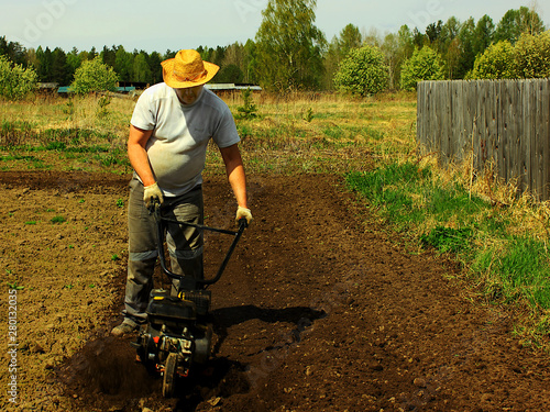 a man tilling ground with motor-cultivator