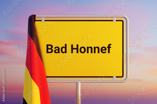 Bad Honnef. Gelbes Schild/Ortsschild. Flagge von Deutschland hängt darüber. Himmel mit Sonnenuntergang oder Sonnenaufgang photo