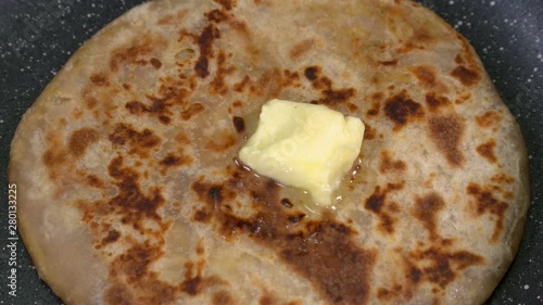 Closeup shot of butter melting on a stuffed parantha.  photo