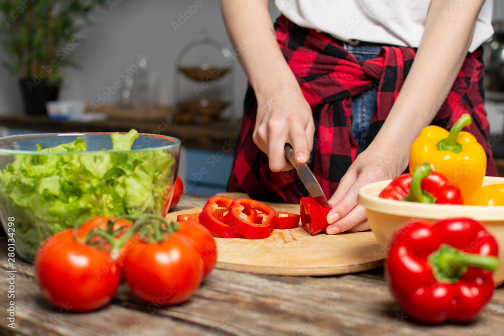 young girl prepares a vegetarian salad in the kitchen, she chops pepper, the process of preparing healthy food, close-up young girl prepares a vegetarian salad in the kitchen, she chops pepper, the process of preparing healthy food, close-up