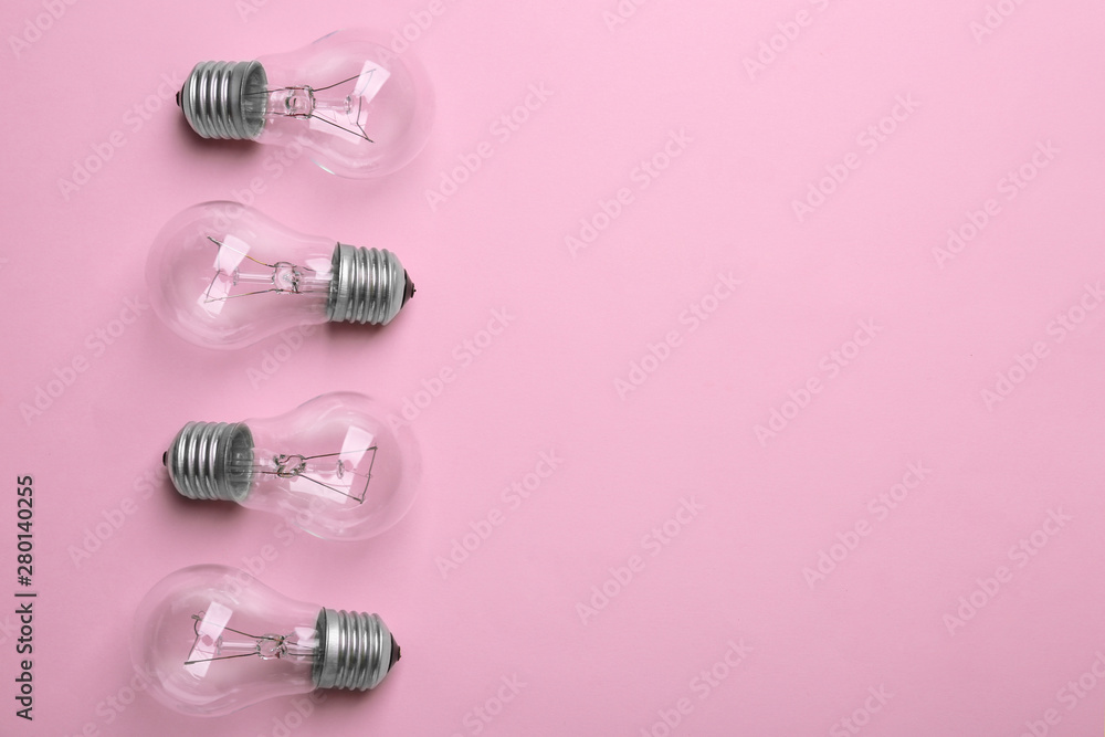New incandescent lamp bulbs on pink background, top view. Space for text New incandescent lamp bulbs on pink background, top view. Space for text