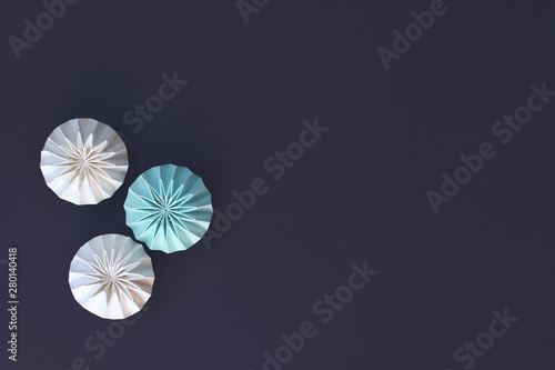 Abstract light teal, and white pleated geometrical lampions on black background with copy space