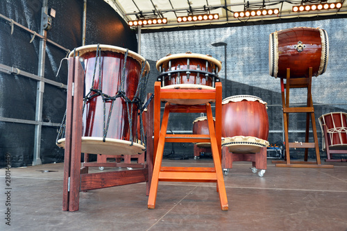 Traditional wooden Japanese Taiko drums with 'Hirado' and 'Okedo' drum in foreground and 'O-Daiko' and 'Nagado' drum in background standing on a stage photo