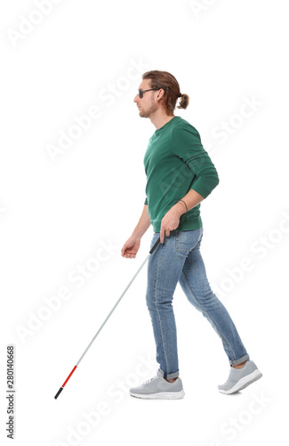 Blind man in dark glasses with walking cane on white background