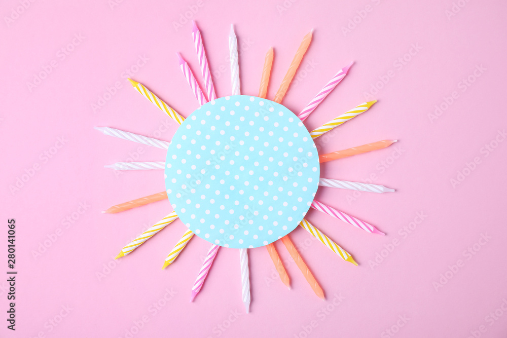 Obraz premium Colorful birthday candles and card on pink background, top view with space for text
