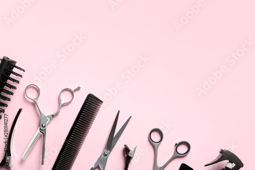 Scissors and other hairdresser's accessories on pink background, flat lay. Space for text