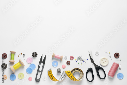 Flat lay composition with scissors and sewing supplies on white background. Space for text photo