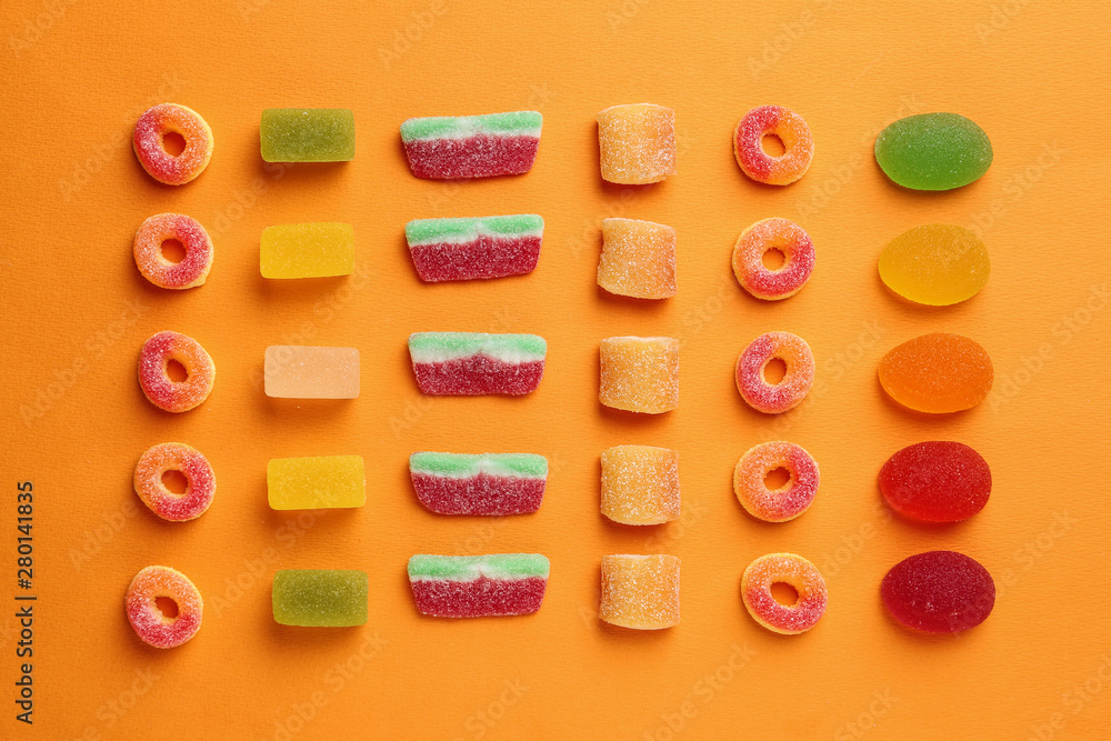Flat lay composition with delicious jelly candies on color background Flat lay composition with delicious jelly candies on color background