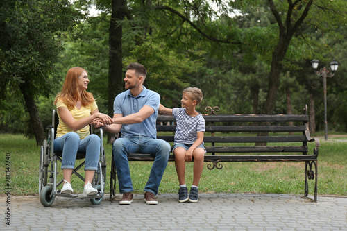 Woman in wheelchair with her family at park