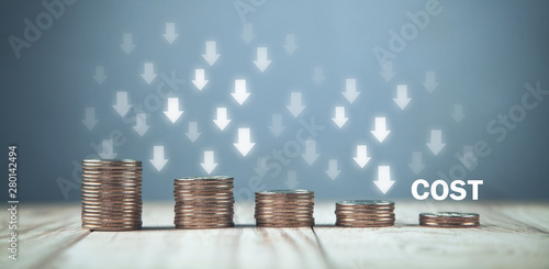 Fototapeta Coins with a Cost text and down arrows.