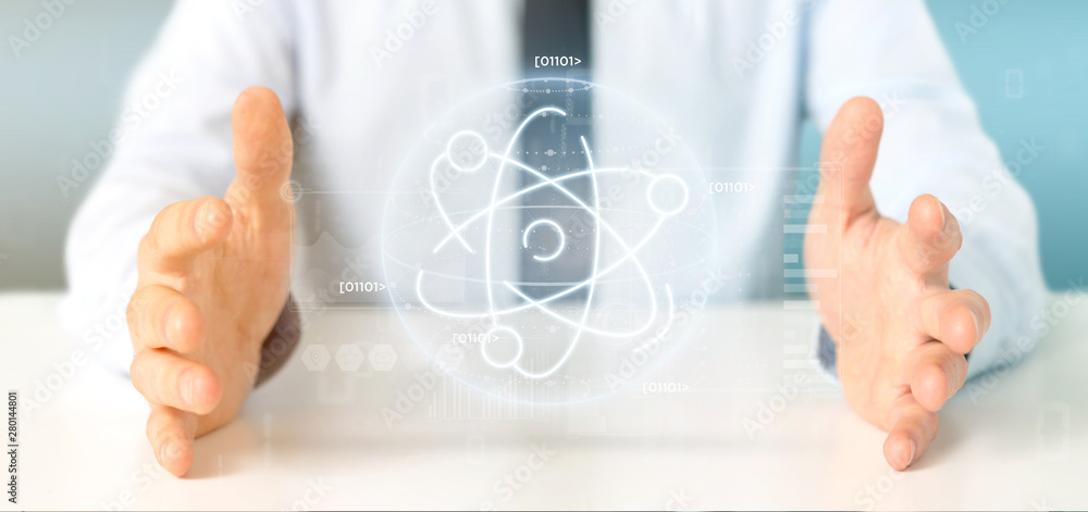 Businessman holding an atom icon surrounded by data Businessman holding an atom icon surrounded by data