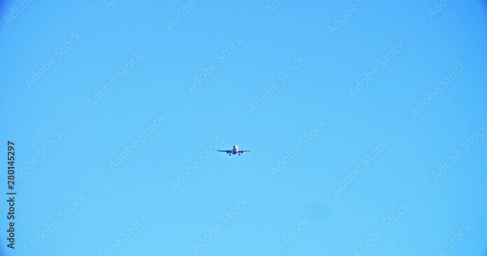 Airplane flying through the clear summer sky on sunny day. Upward view of passenger aircraft soaring in the clouds. Transportation and aviation. Airplane flying through the clear summer sky on sunny day. Upward view of passenger aircraft soaring in the clouds. Transportation and aviation.