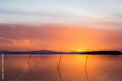 Sunset a Trasimeno lake  Umbria  Italy   with poles on the foreground