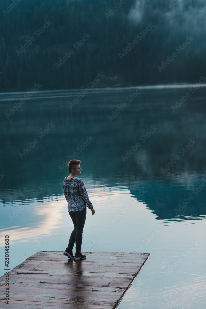 Alone woman contemplates a beautiful mountain lake in silence. Durmitor, Montenegro