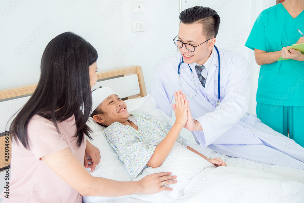 Young Asian male Doctor touching hand with a girl patient who lying on hospital bed. Medicine and health care concept. Young Asian male Doctor touching hand with a girl patient who lying on hospital bed. Medicine and health care concept.