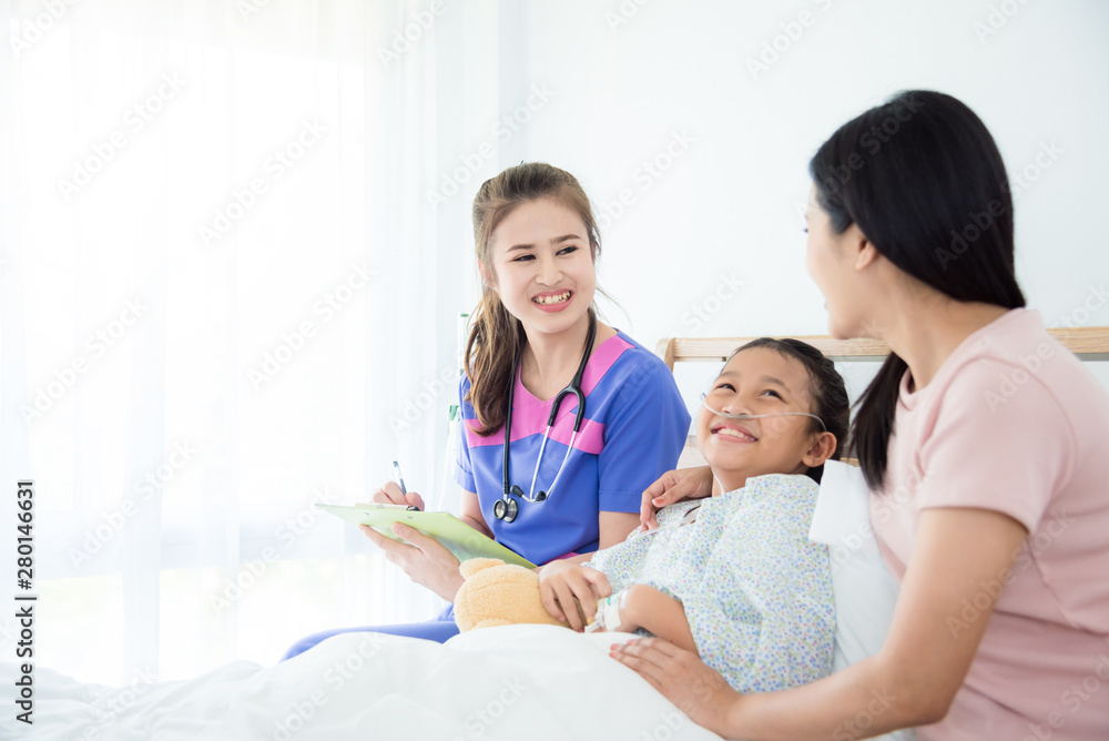 Young asian doctor smiling with girl patient and mother while come to visit them in ward Young asian doctor smiling with girl patient and mother while come to visit them in ward