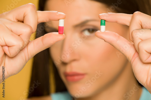 Closeup of woman holding capsules with her fingers