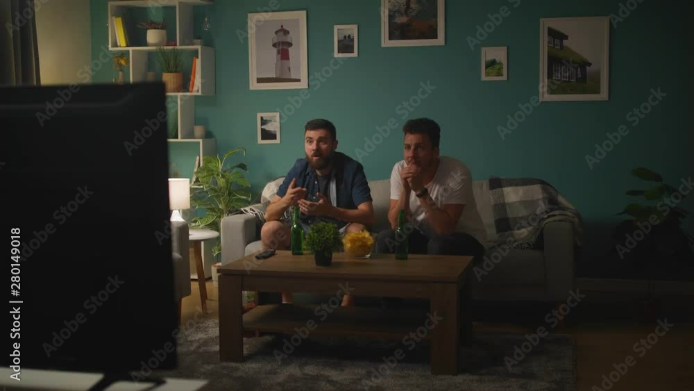Happy friends watching soccer match, giving high five, national team winning Happy friends watching soccer match, giving high five, national team winning