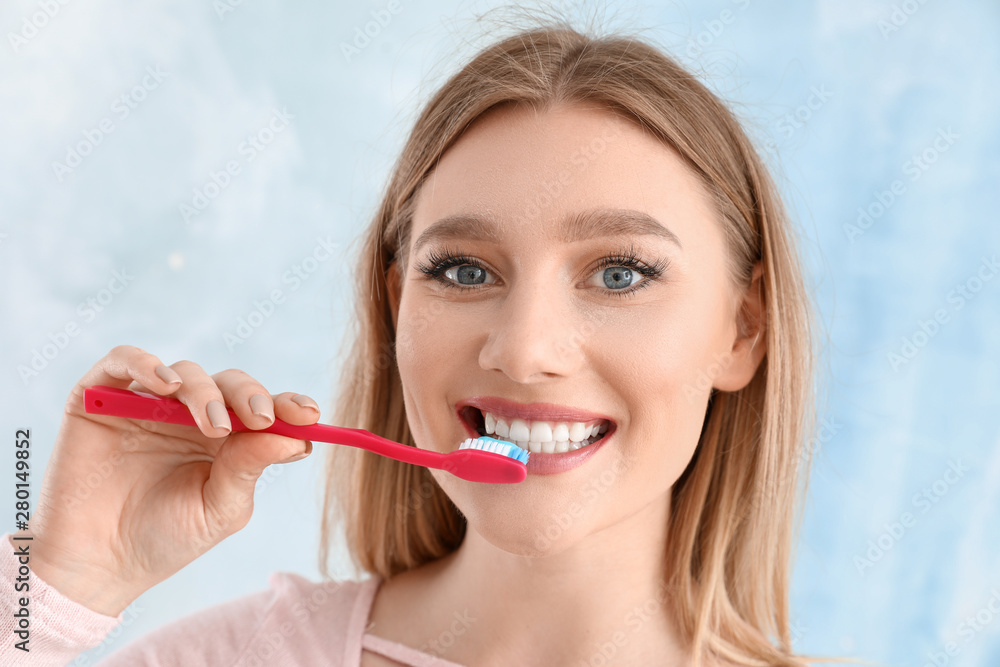 Beautiful woman cleaning teeth on light background Beautiful woman cleaning teeth on light background