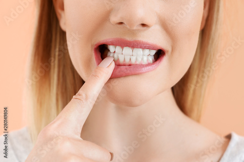 Beautiful woman with healthy teeth on color background, closeup