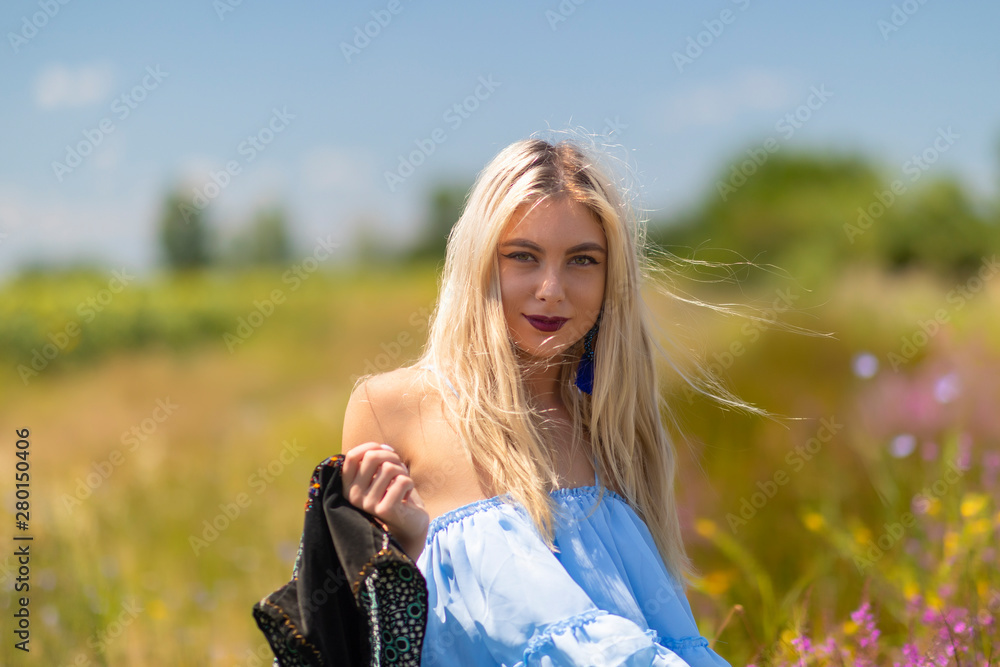 Beauty Girl Outdoors enjoying nature. Beautiful Teenage Model girl in blue dress running on the summer Field.