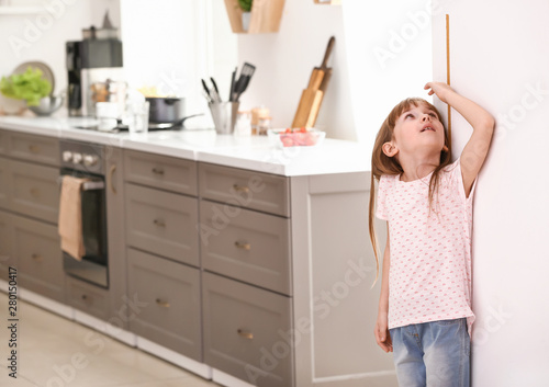 Little girl measuring heigh...