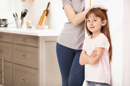 Mother measuring height of ...