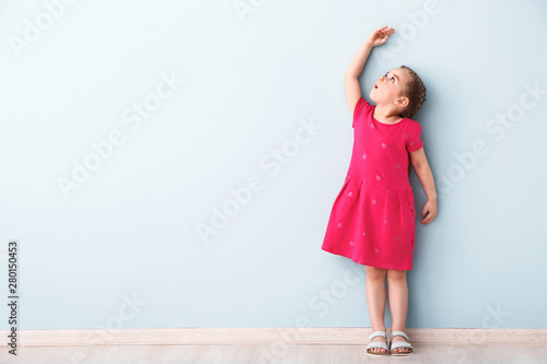 Little girl measuring heigh...
