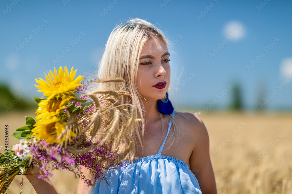 Beauty Girl Outdoors enjoying nature. Beautiful Teenage Model girl in blue dress running on the summer Field.