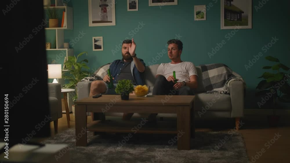 Young men are watching game on TV and anger discussing game and losing team Young men are watching game on TV and anger discussing game and losing team