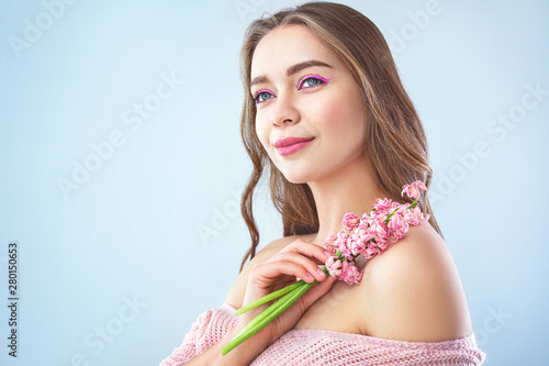 Beautiful young woman with hyacinth flowers on light background © Pixel-Shot