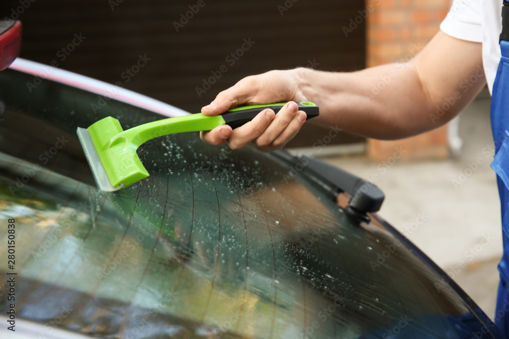Obraz premium Male worker tinting car window outdoors