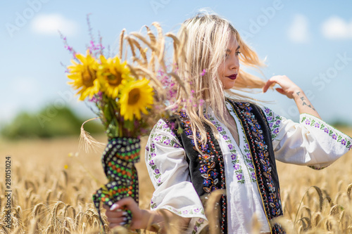 Beautiful girl in traditional costume in a wheat field photo