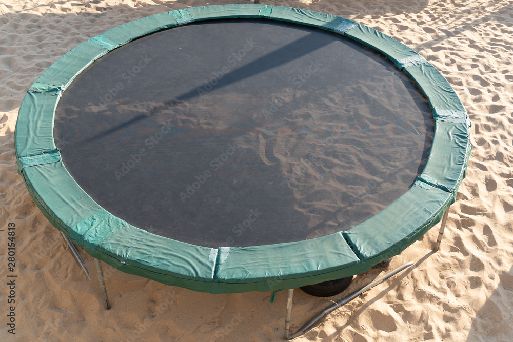 Trampoline children and adults for fun outdoor fitness jumping on sand beach