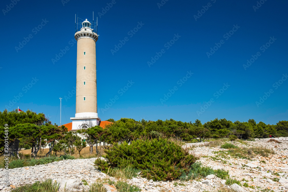 Croatia, island of Dugi Otok, beautiful old lighthouse of Veli Rat on the stone shore among the pines