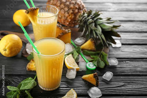 Composition with fresh pineapple juice on wooden table