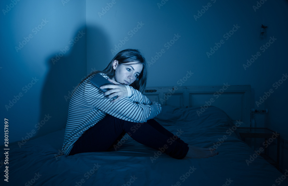 Depressed teenager girl on mobile phone victim of cyberbullying feeling sad, unhappy and lonely Depressed teenager girl on mobile phone victim of cyberbullying feeling sad, unhappy and lonely