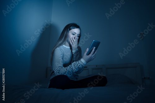 Bilde på lerret Depressed teenager girl on mobile phone victim of cyberbullying feeling sad, unh
