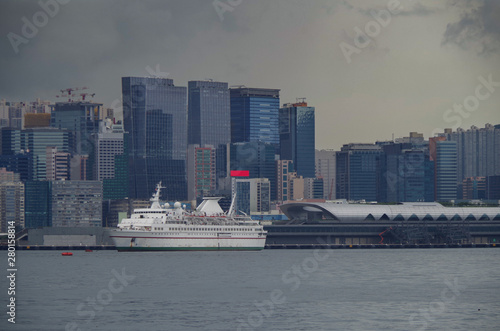 Classic casino cruiseship in front of Kai Tak cruise terminal and Kai Tak Kowloon Bay skyline photo