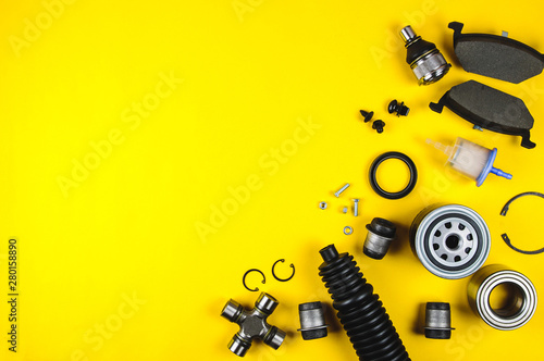 Set of car parts for maintenance on yellow background photo