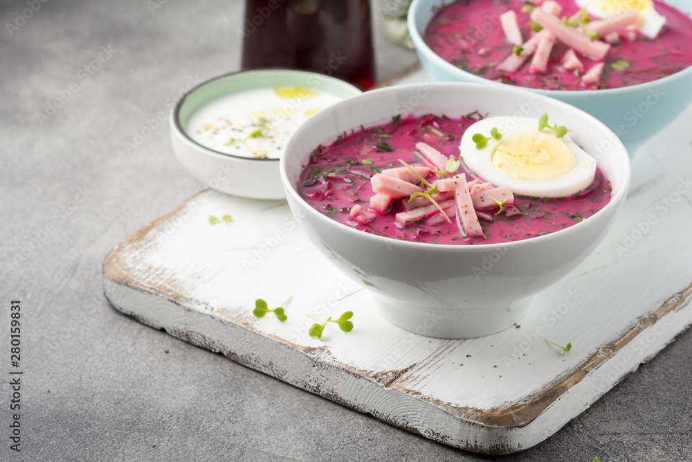 Cold beet soup, traditional Lithuanian dish, summer food. Fresh vegetables (cucumbers, radishes, green onions, cilantro), sour cream, egg, ham Cold beet soup, traditional Lithuanian dish, summer food. Fresh vegetables (cucumbers, radishes, green onions, cilantro), sour cream, egg, ham