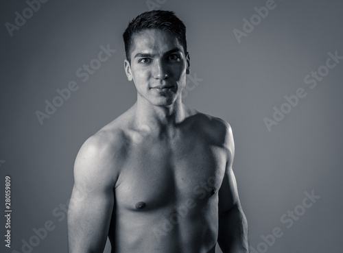 Portrait of strong handsome Athletic man feeling good and happy isolated on neutral background