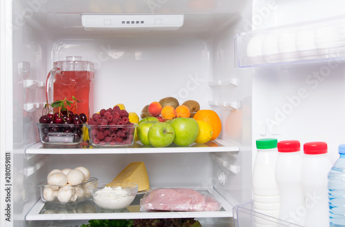 in a white refrigerator, on the top shelf are fruits, berries and a jug with compote, on the bottom mushrooms, cottage cheese, cheese, eggs, and in the door dairy products, kefir, cream and water