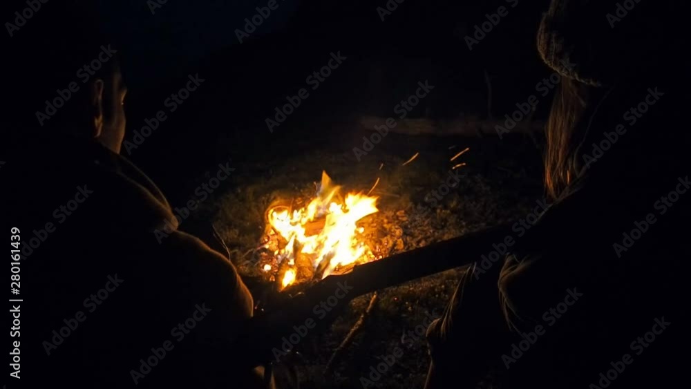 Young couple in mountains, sitting neer bonfire, man playing guitar. Romantic music and happy couple relationships. Romance couple with guitar. Youth lifestyle, man and woman in love Young couple in mountains, sitting neer bonfire, man playing guitar. Romantic music and happy couple relationships. Romance couple with guitar. Youth lifestyle, man and woman in love