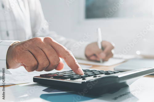 close up hand of businesswoman working on desk in office and using calculator and laptop with pen for calculate. cocept finance and accounting
