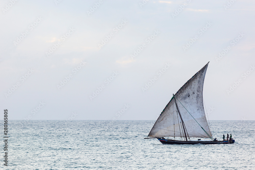 sleek fast traditional dhow sailing boat transporting commodities between the islands and the mainland