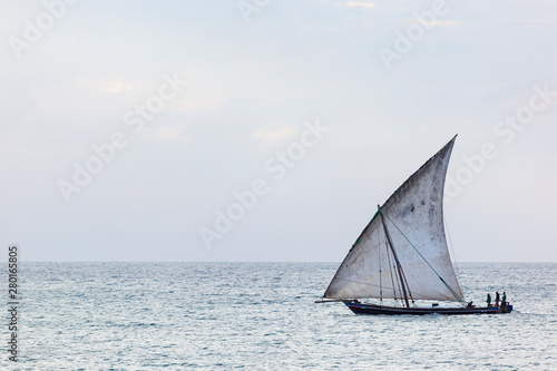 sleek fast traditional dhow sailing boat transporting commodities between the islands and the mainland