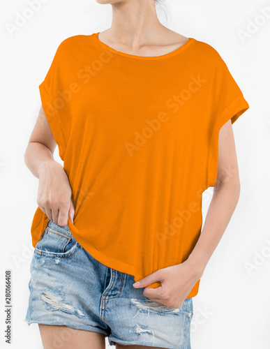 Woman wearing orange t-shirt and short rip jeans with copy space in front side isolated on white background