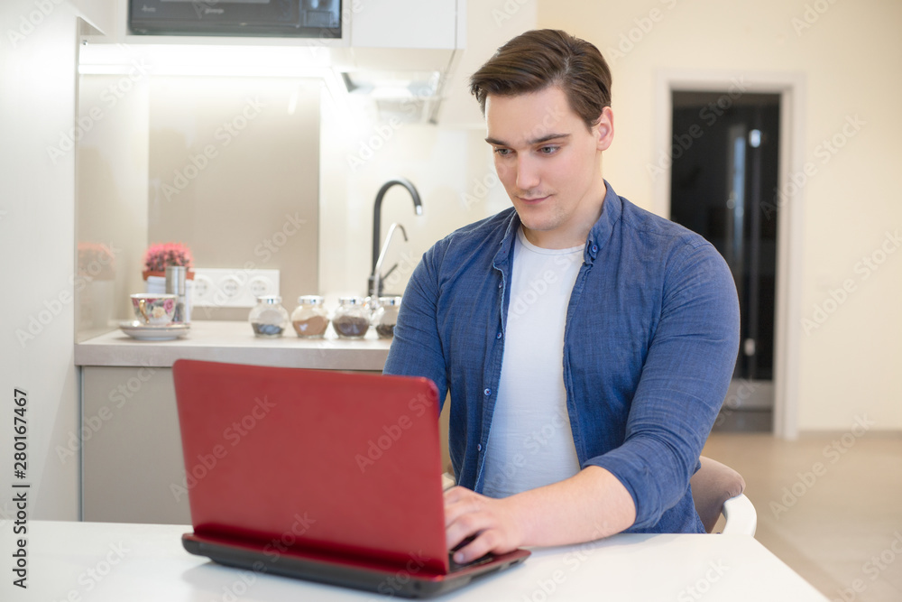 young handsome man working in his laptop from home freelancing young handsome man working in his laptop from home freelancing